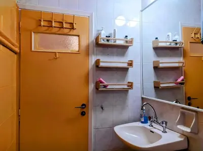 a bathroom with a sink and a yellow door at Charming Stone house, 500 meters to Acropolis in Athens