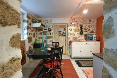a kitchen with a table in a room with stone walls at Charming Stone house, 500 meters to Acropolis in Athens