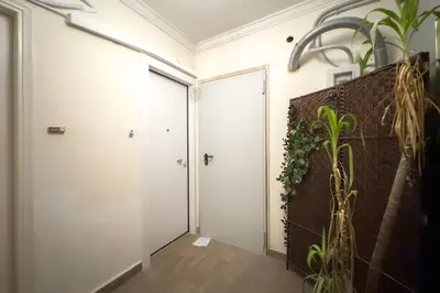 a hallway with two doors and a brick wall at White Luxe Suite in Kolonaki in Athens