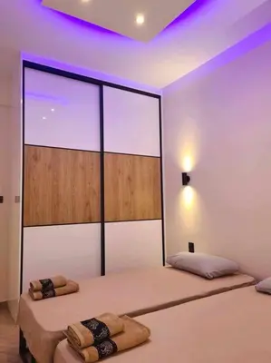 two beds in a room with purple lights at Boho 3siblings in Athens