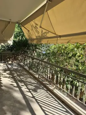 a patio with an umbrella and some plants at Boho 3siblings in Athens