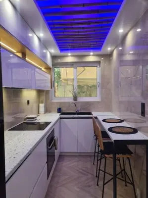 a kitchen with white cabinets and a blue ceiling at Boho 3siblings in Athens