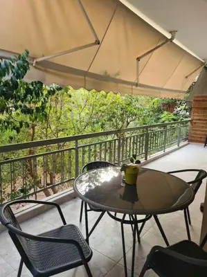 a patio with a table and chairs on a balcony at Boho 3siblings in Athens