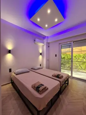 a bedroom with two beds and a blue ceiling at Boho 3siblings in Athens