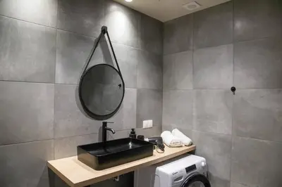 a bathroom with a black sink and a mirror at Stoa Luxury Apartment in Athens