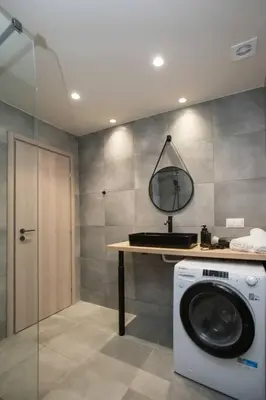 a bathroom with a washing machine and a mirror at Stoa Luxury Apartment in Athens