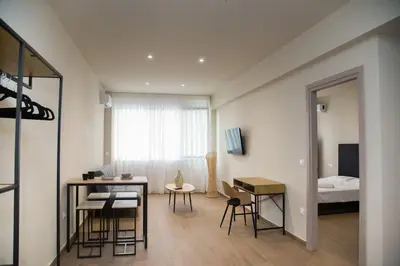 a room with a table and chairs and a bedroom at Stoa Luxury Apartment in Athens