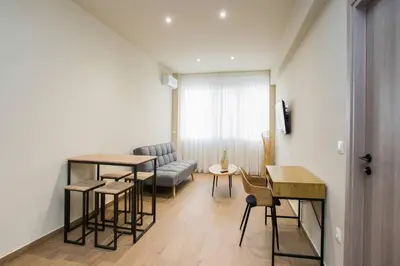 a living room with a table and chairs and a couch at Stoa Luxury Apartment in Athens