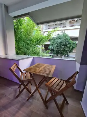 a wooden table and two chairs on a balcony at Luxury 3siblings in Athens