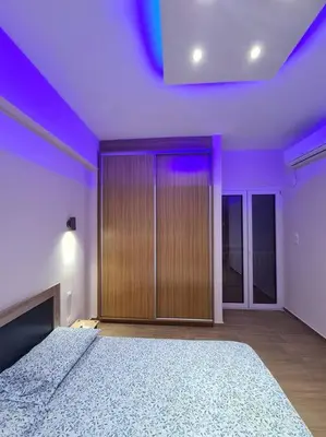a room with a large bed with purple lighting at Luxury 3siblings in Athens