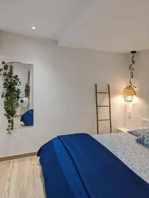 a bedroom with a blue bed and a mirror at MatchBox 3siblings in Athens