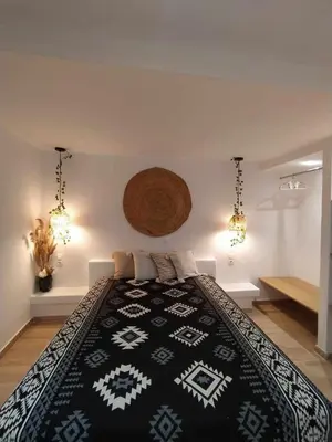 a bedroom with a bed with a black and white blanket at MatchBox 3siblings in Athens