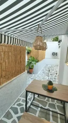 a patio with a wooden table and potted plants at MatchBox 3siblings in Athens