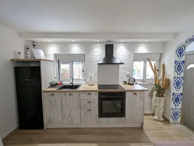 a kitchen with wooden cabinets and a black refrigerator at MatchBox 3siblings in Athens
