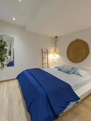 a bedroom with a bed with a blue blanket on it at MatchBox 3siblings in Athens