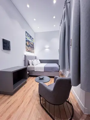 a room with a bed and a chair and a couch at Athinaidos rooms Prime location in Athens