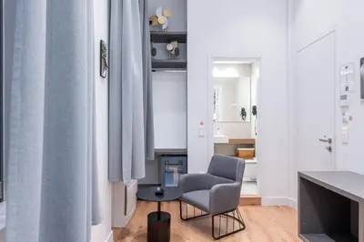 a living room with a chair and a table at Athinaidos rooms Prime location in Athens