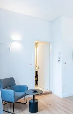 a living room with a blue chair and a table at Athinaidos rooms Prime location in Athens
