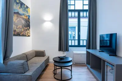 a living room with a couch and a tv at Athinaidos rooms Prime location in Athens