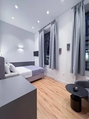 a living room with a bed and a table at Athinaidos rooms Prime location in Athens