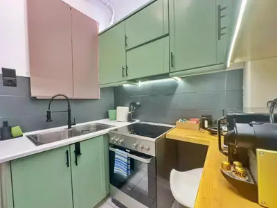 a kitchen with green cabinets and a sink at St Tomas Square Apartment in Athens