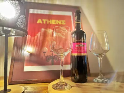 a bottle of wine and two glasses on a table at St Tomas Square Apartment in Athens