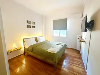 a bedroom with a bed and a television in it at St Tomas Square Apartment in Athens