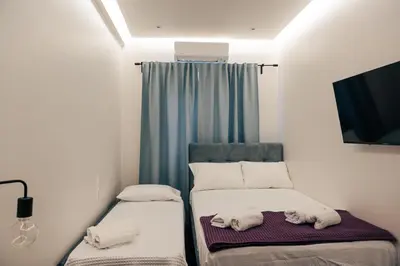 a small room with two beds and a window at athens guest in Athens