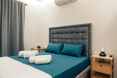 a bedroom with a large bed with blue pillows at athens guest in Athens
