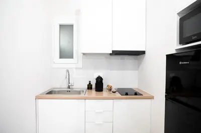 a white kitchen with a sink and a microwave at Athens Horizon Suite by GK Properties in Athens