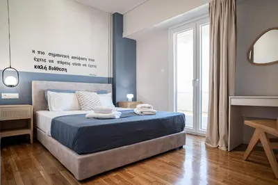 a bedroom with a bed with blue walls and a mirror at Athens Horizon Suite by GK Properties in Athens