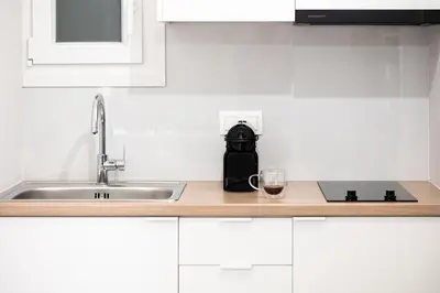 a kitchen counter with a sink and a glass of wine at Athens Horizon Suite by GK Properties in Athens