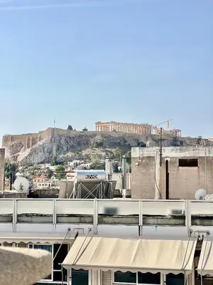 a view of a city with a hill in the background at Penthouse with Terrace and Acropolis View - Themelio Suites in Athens