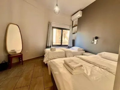 a hospital room with three beds and a mirror at Penthouse with Terrace and Acropolis View - Themelio Suites in Athens