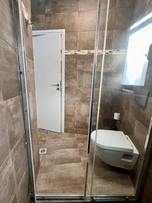a bathroom with a shower with a toilet and a sink at Penthouse with Terrace and Acropolis View - Themelio Suites in Athens