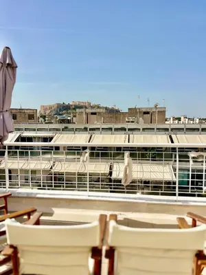 a group of chairs sitting on top of a building at Penthouse with Terrace and Acropolis View - Themelio Suites in Athens