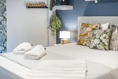 a white bed with two towels on top of it at City Nest Apartment by Cloudkeys in Athens