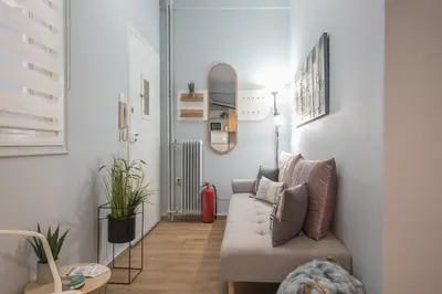 a living room with a couch and a mirror at City Nest Apartment by Cloudkeys in Athens