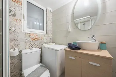 a bathroom with a toilet and a sink and a mirror at City Nest Apartment by Cloudkeys in Athens