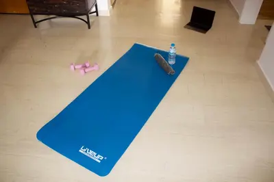 a blue yoga mat with a bottle of water and a pink toy at Welcome to Elena's Athens Suite! in Athens