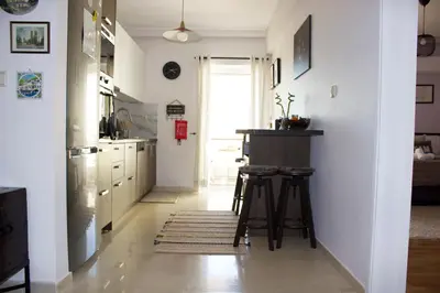 a kitchen with a counter and stools in it at Welcome to Elena's Athens Suite! in Athens