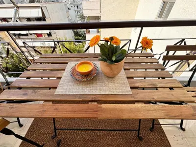 a wooden table with an orange bowl on a balcony at Welcome to Elena's Athens Suite! in Athens