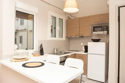 a kitchen with a white refrigerator and wooden cabinets at P24 by SpitiSou in Athens