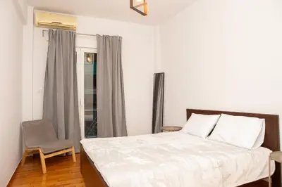a bedroom with a bed and a chair and a window at P24 by SpitiSou in Athens