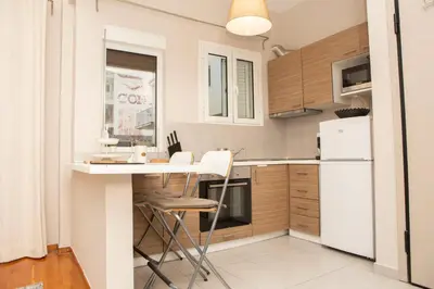 a kitchen with white appliances and a table and chairs at P24 by SpitiSou in Athens