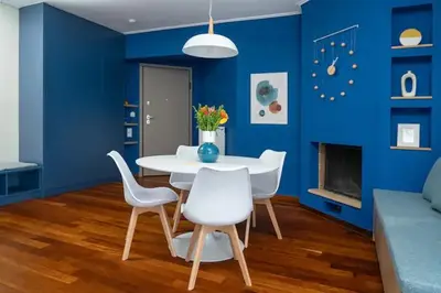 a blue living room with a white table and chairs at Luxury apartment in Alimos in Athens