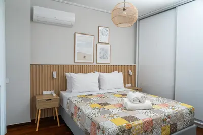 a bedroom with a bed with a quilt on it at Luxury apartment in Alimos in Athens