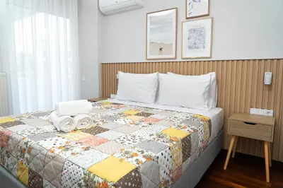 a bedroom with a bed with a quilt on it at Luxury apartment in Alimos in Athens