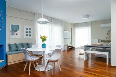 a living room with a table and chairs and a couch at Luxury apartment in Alimos in Athens