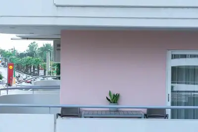 a white building with a bench in front of a building at Luxury apartment in Alimos in Athens